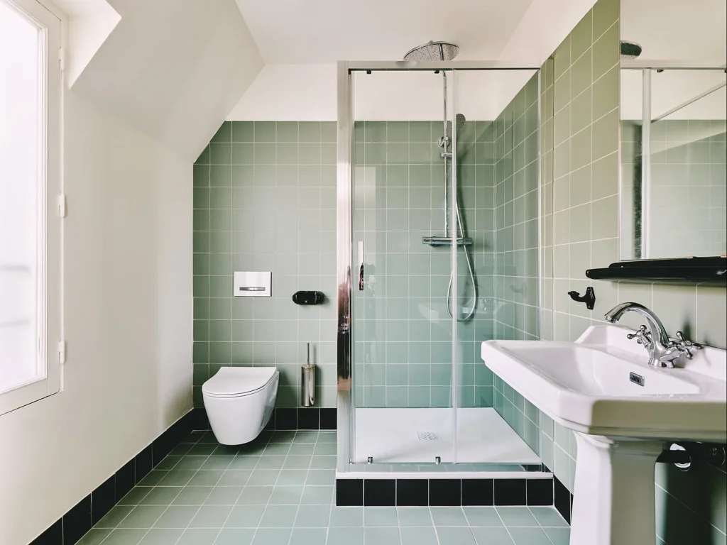 Salle de bain avec douche à l'italienne et lavabo avec des carreaux vert